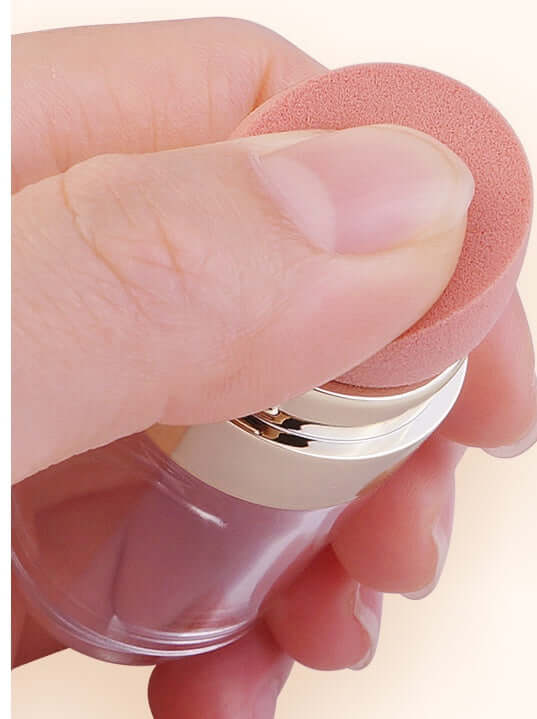 Hand holding a portable 5-in-1 makeup brush with a soft applicator for foundation and eyeshadow.
