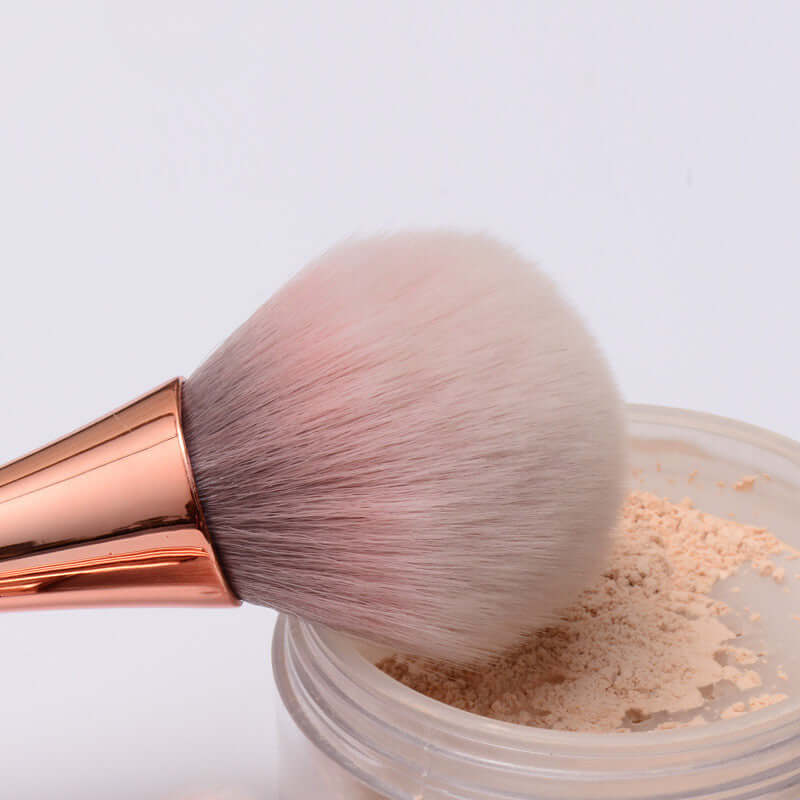 High-quality make-up brush with soft bristles and rose gold handle, perfect for flawless application of powder cosmetics.
