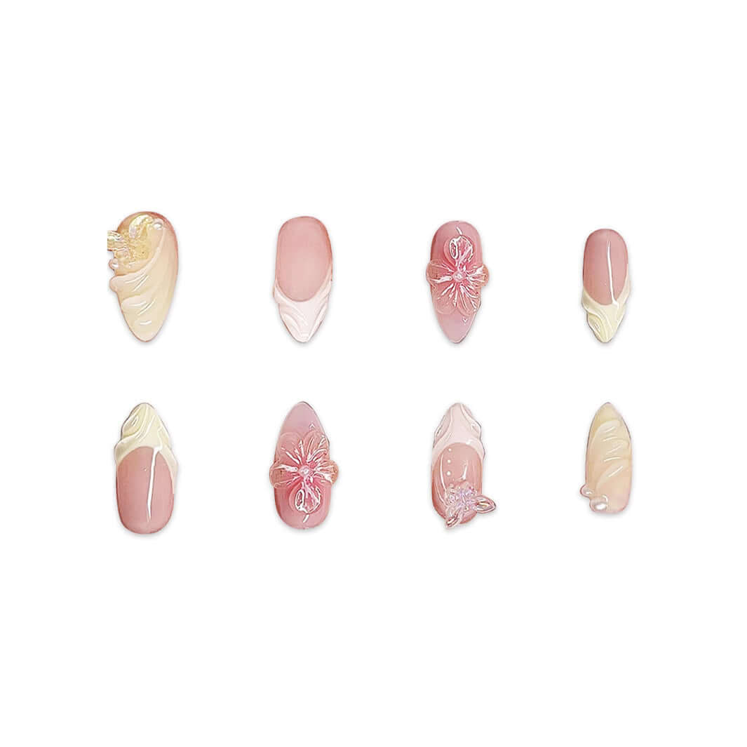 Set of eight handmade almond-shaped short nails featuring floral designs in soft pink and cream shades.