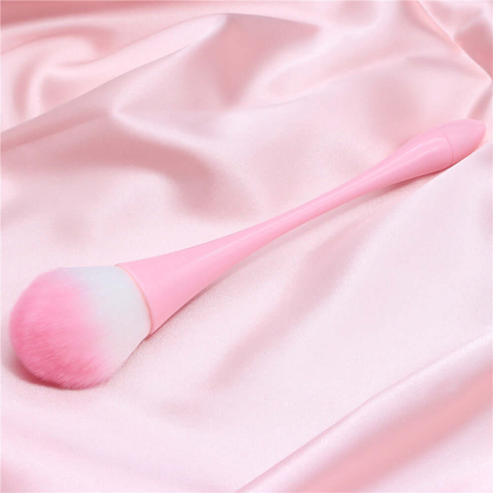 Professional pink make-up brush on satin fabric for flawless cosmetic application.