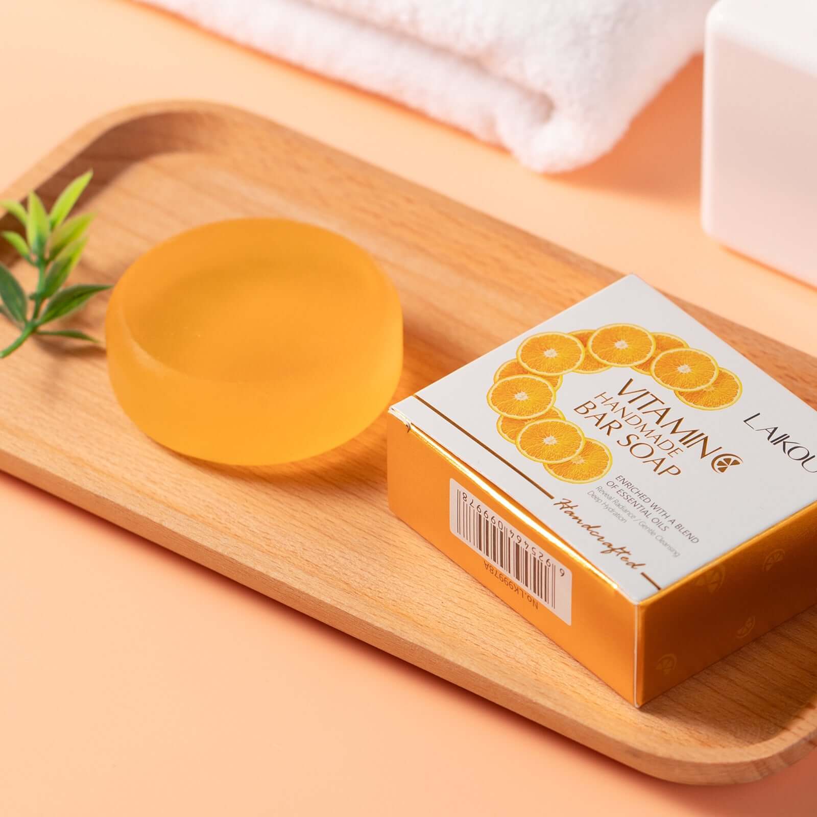 Handmade turmeric soap with vitamin C on a wooden tray, highlighting its moisturizing properties for all skin types.